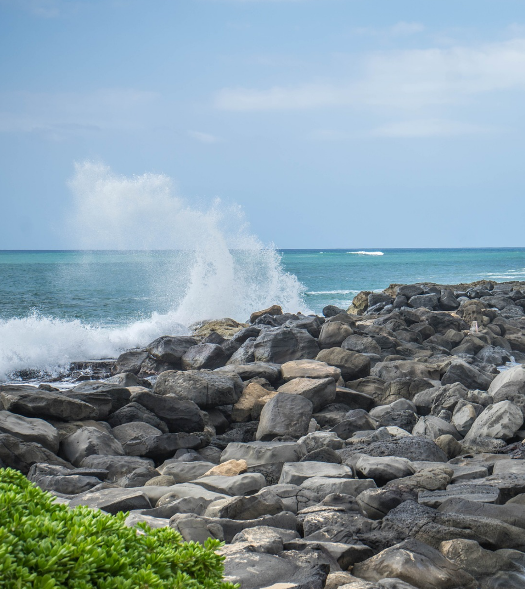 waves crashing against a rocky shore in oahu